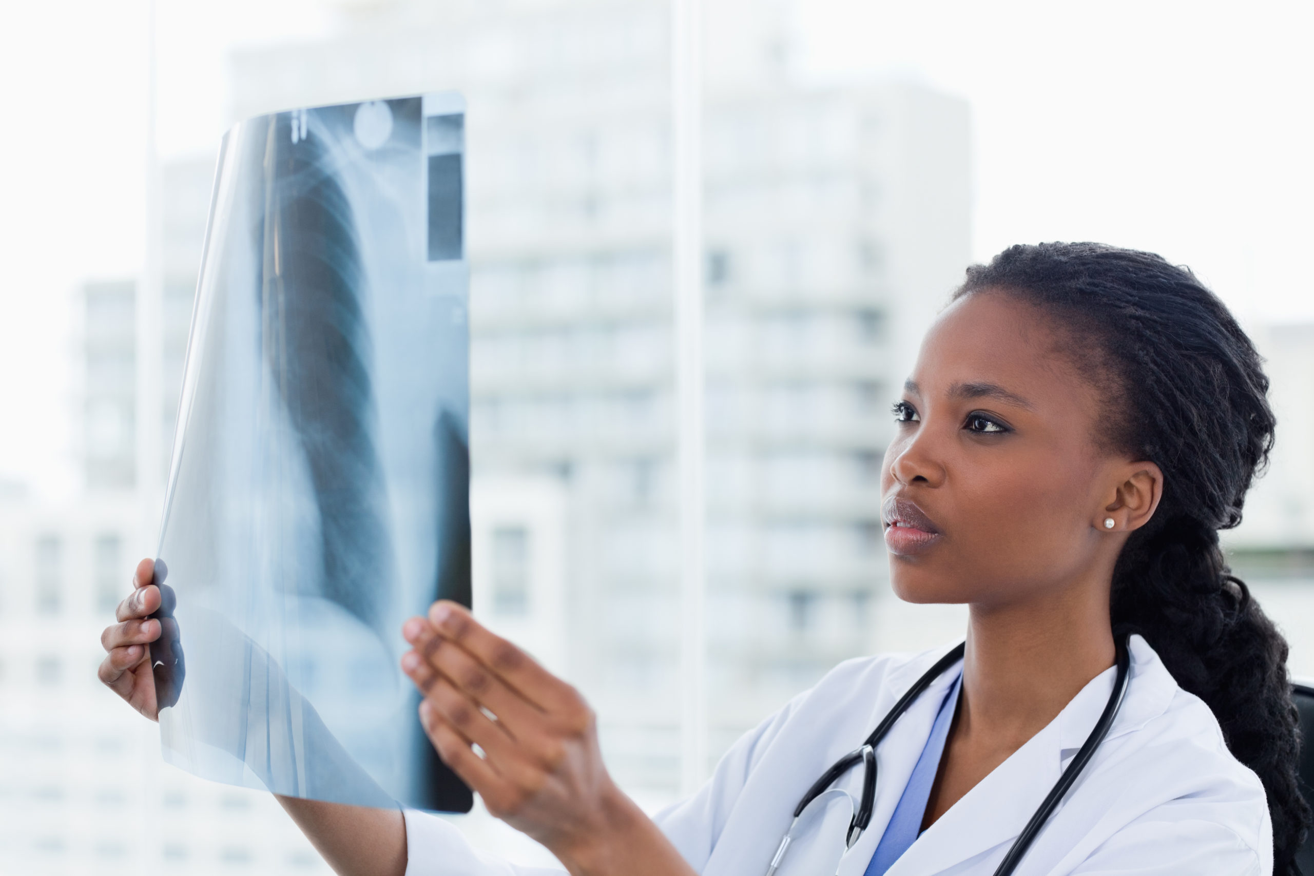 Female doctor looking at a set of X-rays in her office