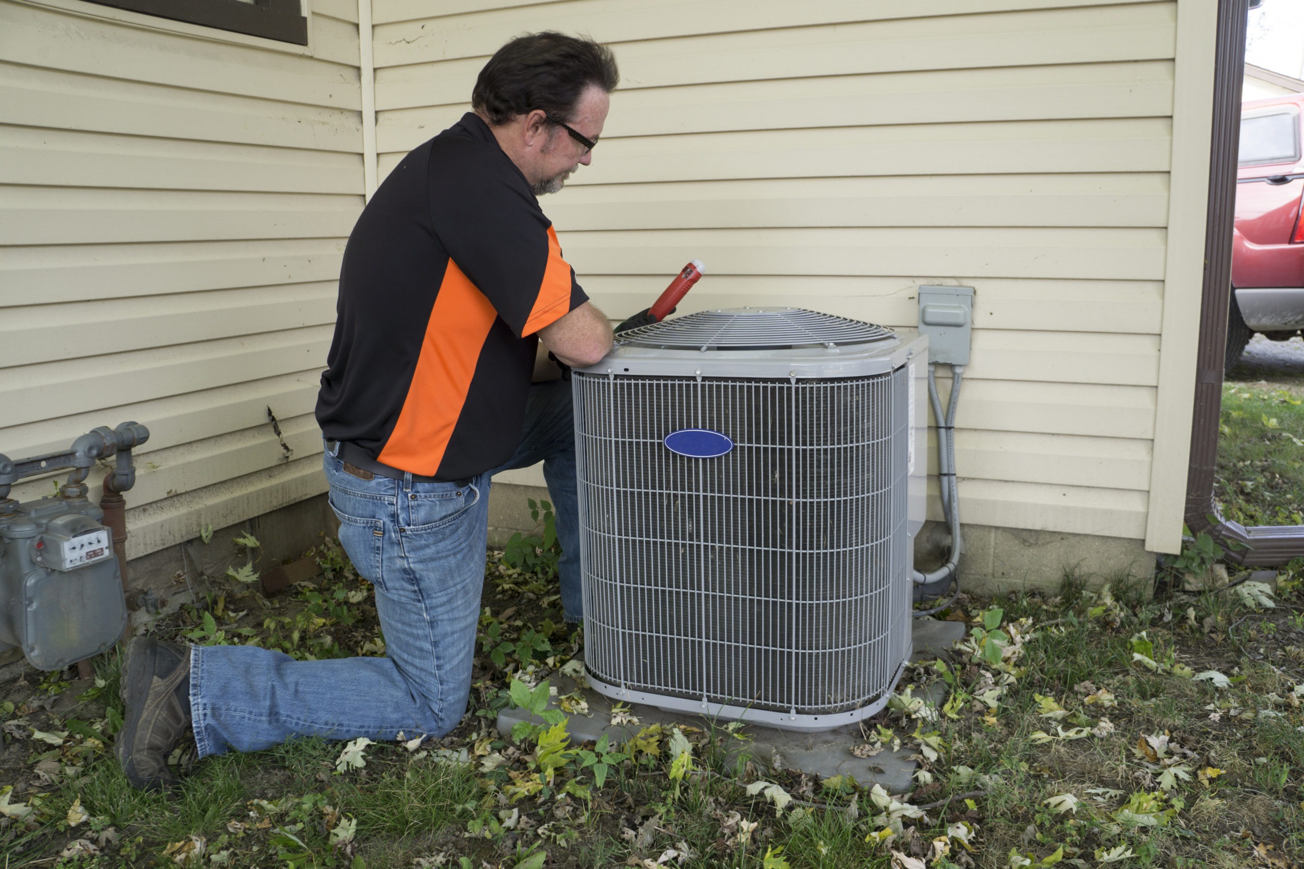 Repairman Checking AC Unit for Voltage